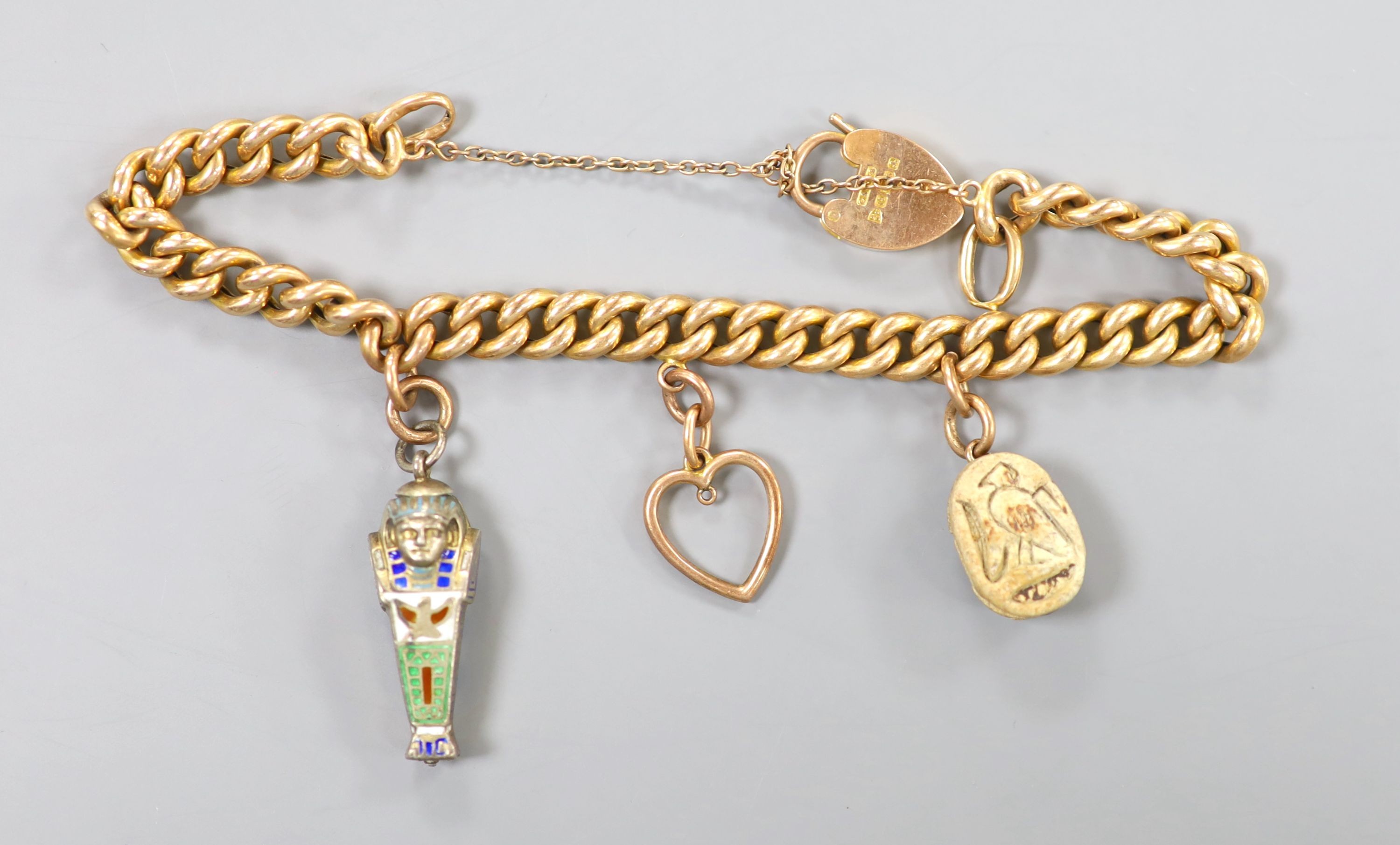 An Edwardian 15ct gold, curb link charm bracelets, hung with three assorted charms, gross weight 23.2 grams.